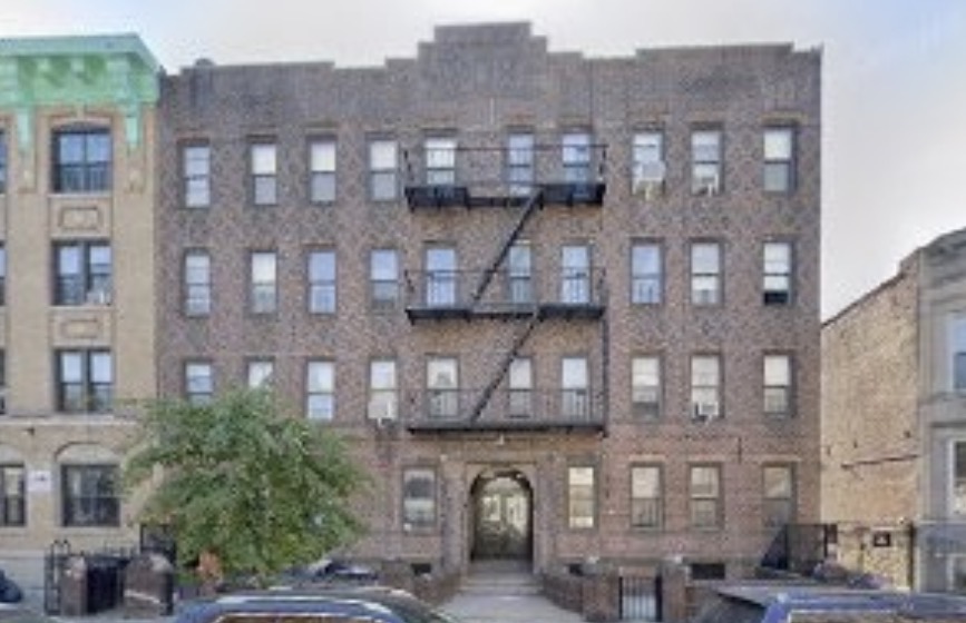 1392 Sterling Place, a five-story prewar brick apartment building in Crown Heights, Brooklyn, with fire escapes above a central arched entryway