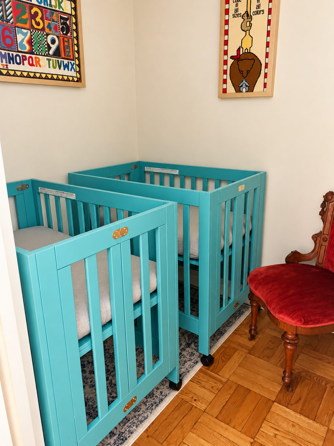 Two small cribs set up in the makeshift nursery in a New York City apartment