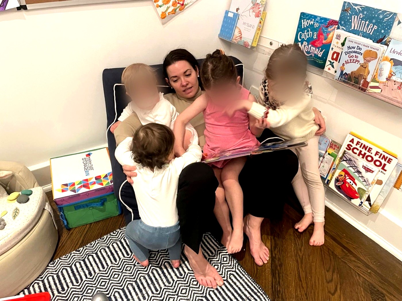 Reading a book to four young children at home in a New York City apartment