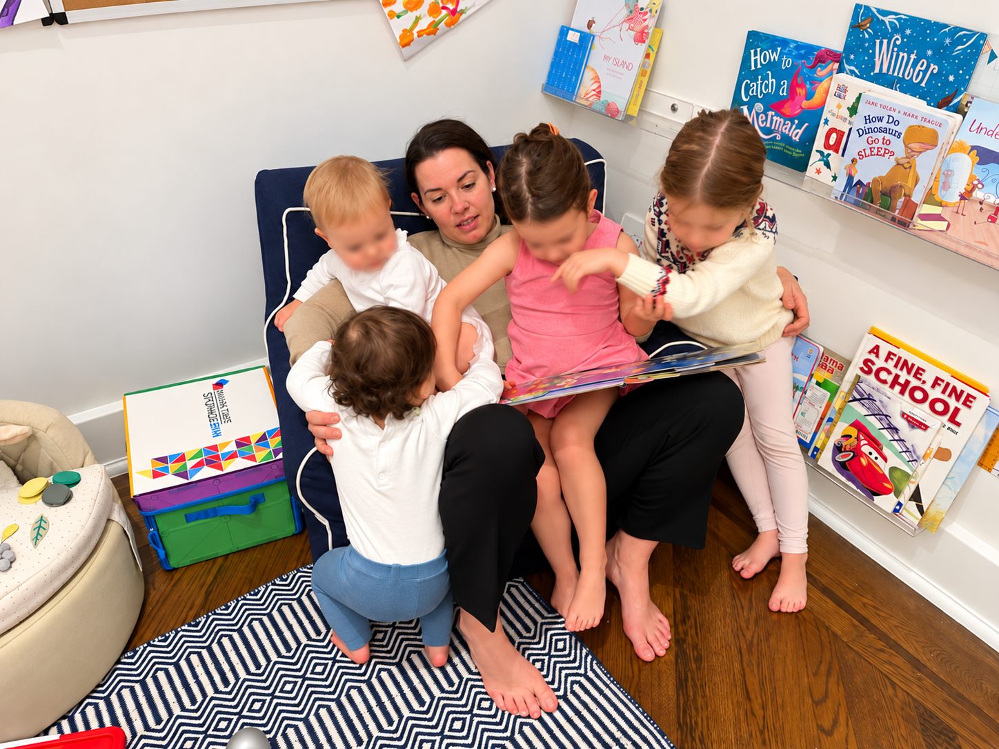 Reading a book to four young children at home in a New York City apartment